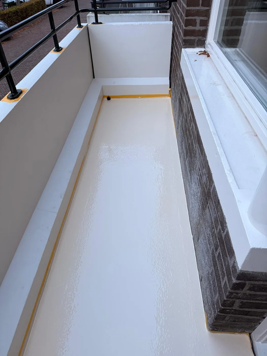 Hetzelfde balkon na de vloercoating: een gesloten, witte en onderhoudsvriendelijke vloer