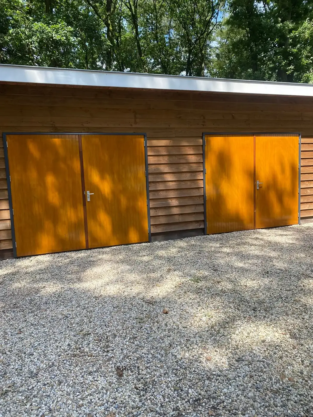 Houten garagedeuren en gevelbetimmering, opnieuw behandeld